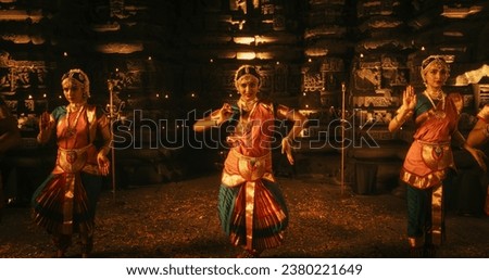 Portrait of Three Expressive Young Indian Dancers Performing Folk Dance Choreography Inside an Ancient Temple. Women in Traditional Clothes Dancing Bharatanatyam in Colourful Sari Royalty-Free Stock Photo #2380221649
