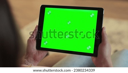 Close up of woman holding a digital tablet with green screen. Internet online, chroma key screen concept.