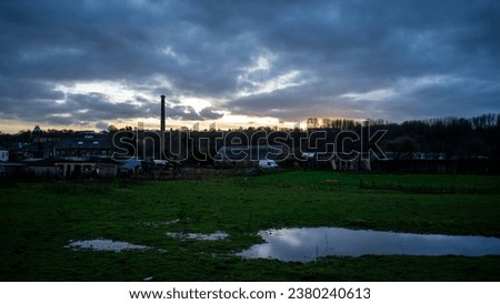 puddle on the grass. Puddle of water on the grass at the horse farm after the rain. sunset cloudy landscape