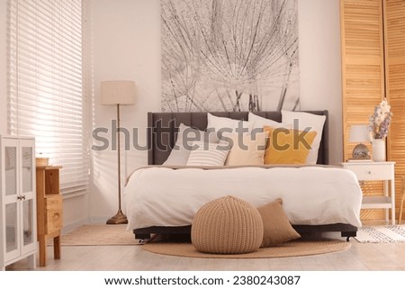 Light bedroom interior with comfortable bed and beautiful picture