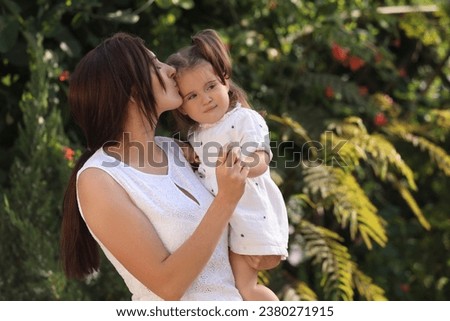 Mother with her cute daughter spending time together in park