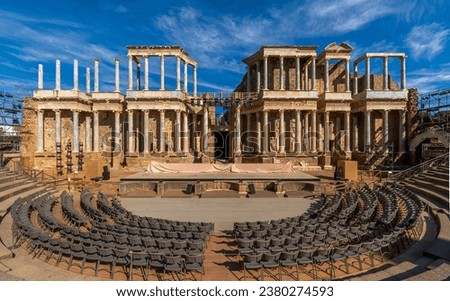 Mérida Roman theater from behind with a view of the chairs, granite steps and the stage scaenae frons of classical Roman columns and statues for the Merida International Classical Theater Festival. Royalty-Free Stock Photo #2380274593