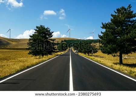 Wind farm with turbines on the mountains. Eco-sustainable industry with nature-friendly technologies for clean energy in a better environment. Conceptual mountainous landscape for renewable