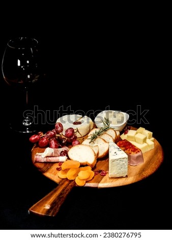 Aerial picture for delicatessen Food Still Life: Cheese, Grapes, Crackers, brie cheese, blue cheese, bacon on a Dark Background. Concept: premium tapas