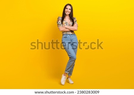 Full length photo of good mood girl with long hairdo dressed flower print blouse standing arms crossed isolated on yellow color background