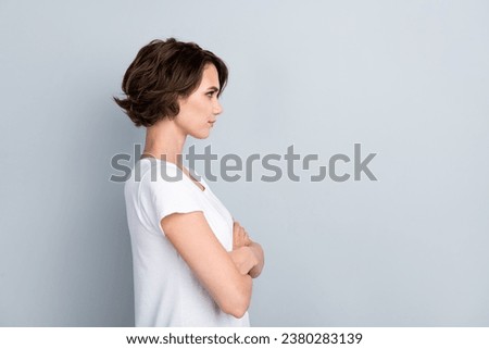 Side profile photo of confident serious girl wear stylish t-shirt look empty space hold arms crossed isolated on gray color background Royalty-Free Stock Photo #2380283139