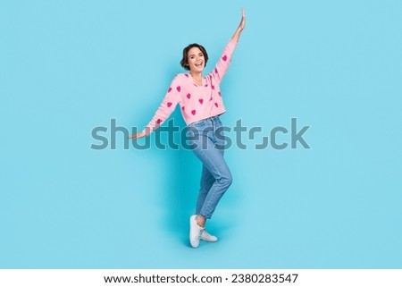 Full body portrait of cheerful overjoyed lady raise arm have good mood dancing isolated on blue color background