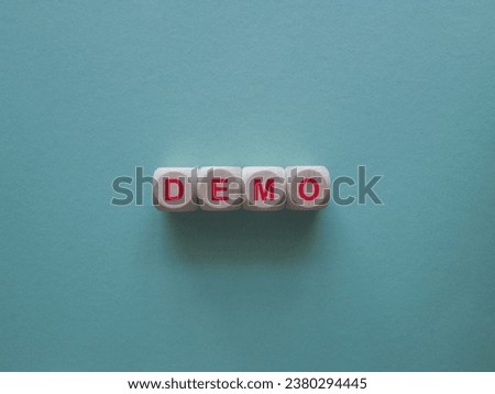 The red word Demo on wooden cubes. Blue background. An extensive concept of the word demo applied in different fields of activity. Business concept. Copy space.