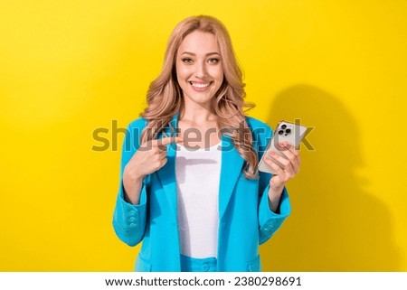 Portrait of lovely cheerful classy girl toothy smile indicate finger arm hold smart phone isolated on yellow color background Royalty-Free Stock Photo #2380298691