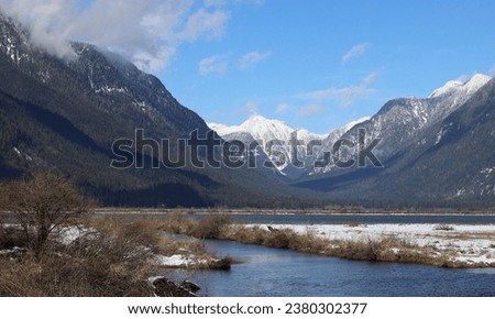 Cold winter day on river snow-capped between mountains