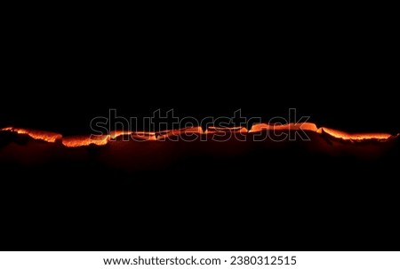 burning paper, glowing edge of paper on a black background Royalty-Free Stock Photo #2380312515