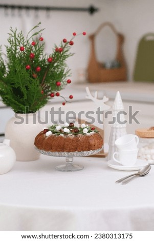 Christmas home interior in white kitchen Christmas chocolate bundt cake with fresh berries and rosemary. Winter baking. christmas trees. Teapot, cups. High quality photo