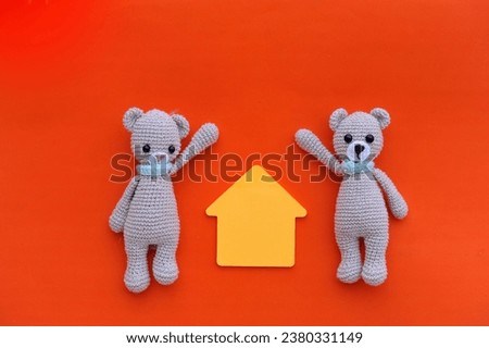 couple of knitted bears holding paper house, dream of realizing the purchase of a new house
