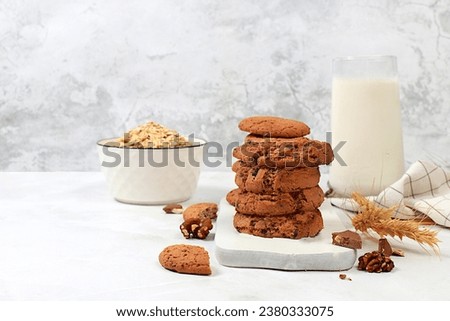 Freshly baked homemade oatmeal cookies with chocolate chips and gluten free nuts with ears on concrete background,modern bakery and grain food concept.Healthy breakfast with ingredients,