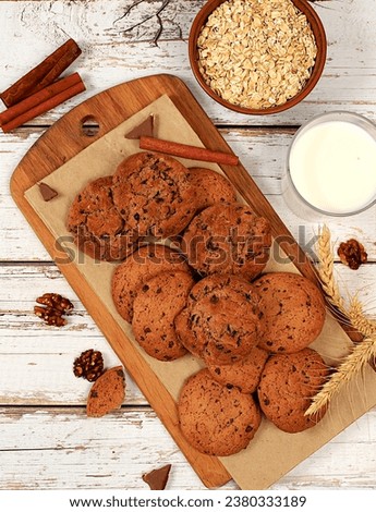 Homemade chocolate chip and nut gluten free oatmeal cookies with ears on wooden background,modern bakery and grain food concept.Healthy breakfast with ingredients,top view,selective focus,