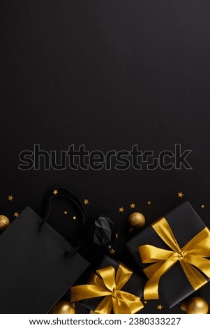 Hunting for christmas gift ideas. Top view vertical composition of gift boxes, package, festive ornaments, stars confetti on black background with promo area