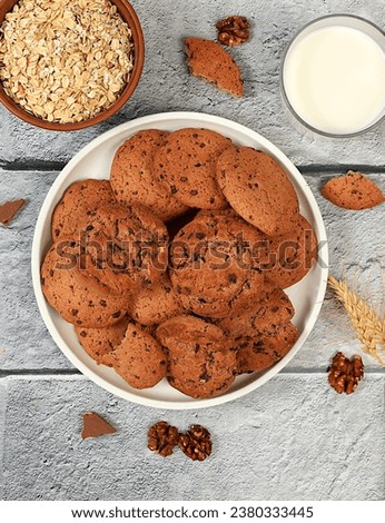 Freshly baked homemade oatmeal cookies with chocolate chips and gluten free nuts with ears on concrete background,modern bakery and grain food concept.Healthy breakfast with ingredients,top view