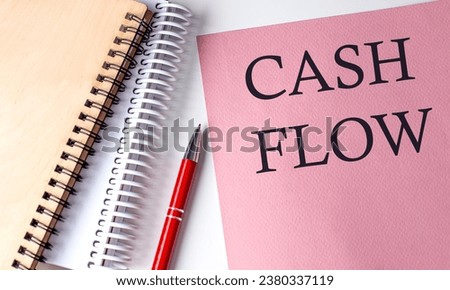 CASH FLOW word on pink paper with office tools on white background