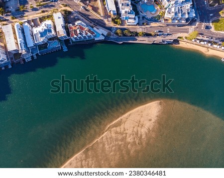 sunset over north bribie island and caloundra in south east queensland, australia; people passing to the island during low tide; Pumicestone Passage Royalty-Free Stock Photo #2380346481