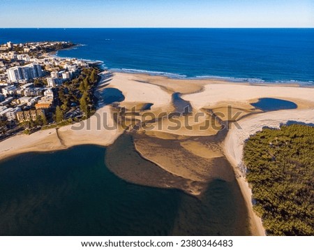 sunset over north bribie island and caloundra in south east queensland, australia; people passing to the island during low tide; Pumicestone Passage Royalty-Free Stock Photo #2380346483