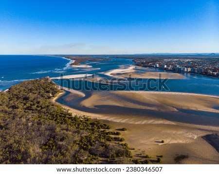 sunset over north bribie island and caloundra in south east queensland, australia; people passing to the island during low tide; Pumicestone Passage Royalty-Free Stock Photo #2380346507