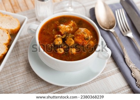 Cocido Andaluz - traditional Spanish dish, thick and hearty stew made with meat, lard, sausages, legumes and vegetables, cooked over low heat Royalty-Free Stock Photo #2380368239