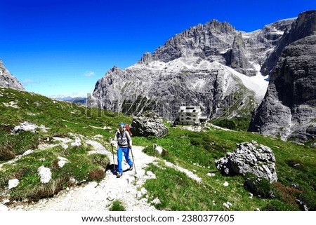 Female hiker in front of the Zsigmondy or Comici hut, Sexten Dolomites, Alta Pusteria, South Tyrol, Italy Royalty-Free Stock Photo #2380377605