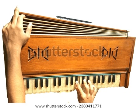 A boy Playing the ancient Harmonium.Hands holding a wooden instrument.