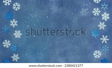 snowflakes border on blue festive background. winter holiday background. flat lay, copy space.