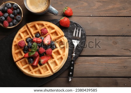 Tasty Belgian waffle with fresh berries served on wooden table, flat lay. Space for text Royalty-Free Stock Photo #2380439585