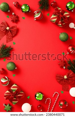 Christmas frame of festive decorations, balls ornaments, confetti, gift boxes on red background. Flat lay, top view, copy space.