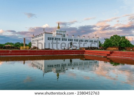 Maya Devi Temple with Ashoka Pillar and it's reflection in sacred bathing pond in Lumbini, Nepal. The exact birthplace of Lord Buddha Siddhartha Gautama and one of the Eight Great Places of Buddhism. Royalty-Free Stock Photo #2380452763