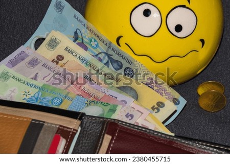 Wallet with LEI banknotes (RON-Romanian money) and a confused smilet face,selective focus Royalty-Free Stock Photo #2380455715
