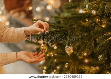 The Christmas tree, adorned with glistening ornaments and twinkling lights, stands tall as a beacon of holiday cheer. Its fragrant boughs cradle cherished memories and hopes for the future.  Royalty-Free Stock Photo #2380459339