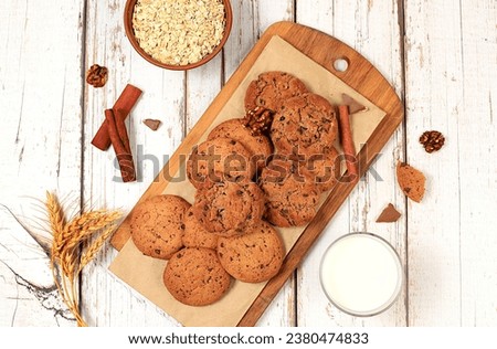 Homemade chocolate chip and nut gluten free oatmeal cookies with ears on wooden background,modern bakery and grain food concept.Healthy breakfast with ingredients,top view,selective focus,
