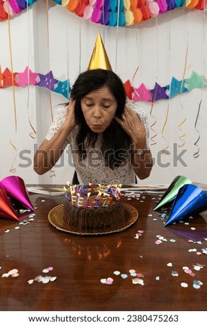 A woman blows out candles on her birthday. My Real Holiday