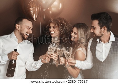 Group of elegantly dressed people celebrating a holiday or event, drinking sparkling wine.