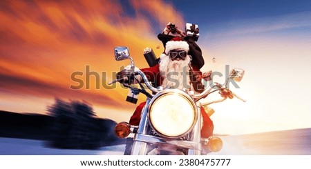 Cool Santa Claus biker riding a fast motorbike at sunset and delivering Christmas gifts