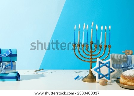 Hanukkiah, gingerbread, gift boxes and donut on blue background, space for text