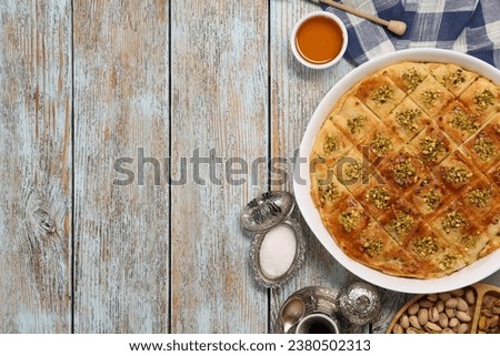 Delicious sweet baklava served on light blue wooden table, flat lay. Space for text Royalty-Free Stock Photo #2380502313