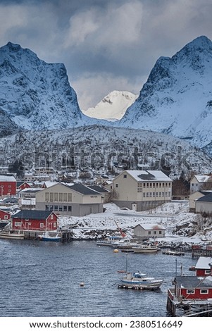 Hamnoy Fishing Village at Lofoten Islands in Norway Along With Red Rorbu Houses with High Snowy Mountains on Background.Vertical Shot