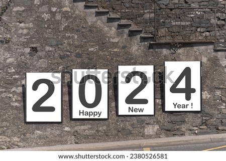Happy New Year 2024,  billboards in Lugano on a stone wall by the street.