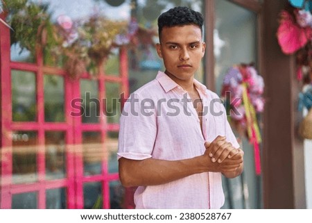 Young latin man with relaxed expression standing at street
