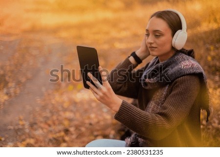 Tablet, backpack and woman traveling in nature in the forest in search of adventure, weekend trip or vacation, digital technology, map in the phone, Google map, taking a photo of herself on the phone