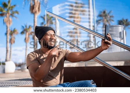 Happy black man taking a self photo with a smartphone.