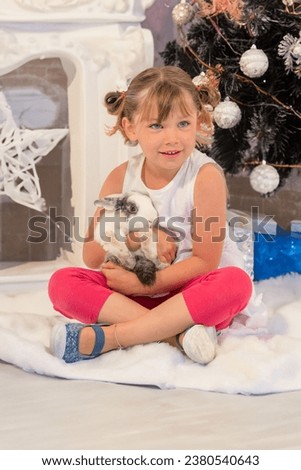 Pretty young girl in her house with her rabbit as a Christmas present