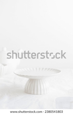 Empty tableware - white plate cakestand on white table as a background for a dessert Royalty-Free Stock Photo #2380541803