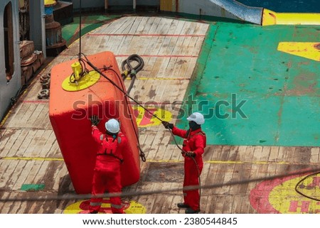 Procced loading of pennant wire, anchor buoy by ship crew to be used for anchor handling or anchor job activities Royalty-Free Stock Photo #2380544845
