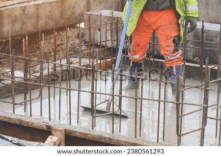 Concrete cast-in-place work. Builder level wet concrete. Concrete works on buildiiing construction site Royalty-Free Stock Photo #2380561293