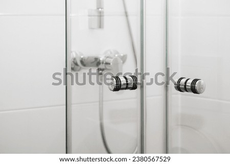 Shower Cabin Door Handle. Chrome Handles in Glass Shower Stall Door in White Tiles Modern Bathroom Interior.  Royalty-Free Stock Photo #2380567529